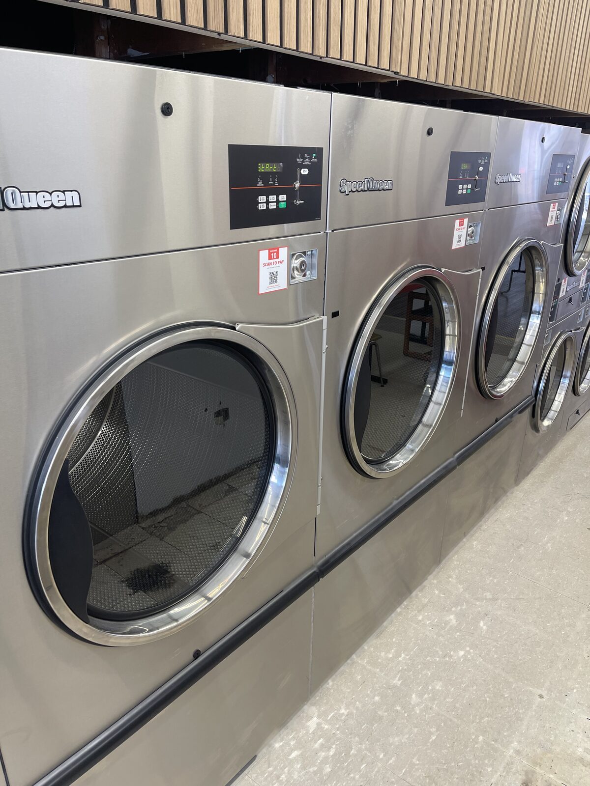 Bank of Speed Queen 75 lb high-capacity dryers at Parvich Laundry
